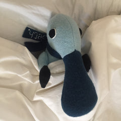 blue duck billed platypus soft toy in bed