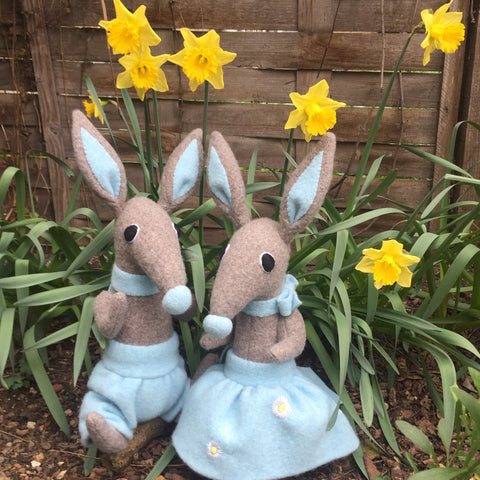 Boy and girl bunny rabbits with daffodils