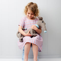 Dachshund in grey with blue collar sitting with a little girl looking down